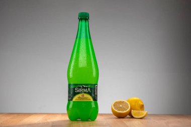 İstanbul Türkiye 08.01.2023: Maden suyu. Tahta zemin ve beyaz zemin üzerinde limonlu ve vitaminli maden suyu. Yanında dilimlenmiş limon olan bir litre maden suyu..