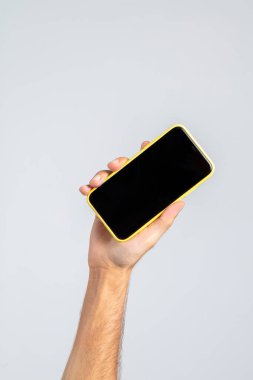 Elinde akıllı telefon tutan bir adam, stüdyoda ve beyaz arka planda, akıllı telefonun ekranı boş, reklamları ve görüntüleri yerleştirmek için. Yüksek çözünürlüklü resim