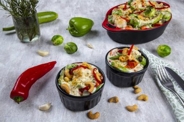 Vejetaryen yemeği. Kızarmış kabak, Brüksel lahanası, karnabahar, fıstık, biber ve sarımsaktan oluşan bir vejetaryen yemeği. Üzerine peynir eklenmiş fırında sunum.