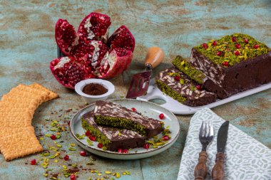 Ev yapımı mozaik kek. Geleneksel nemli pasta, çikolata, bisküvi, nar ve yeşil şam fıstığı..