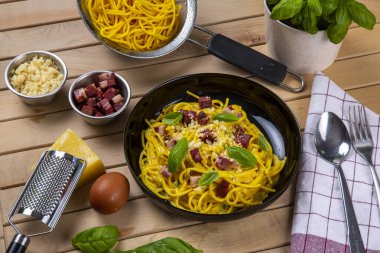 Siyah bir masada et soslu makarna ve parmesan peyniri..