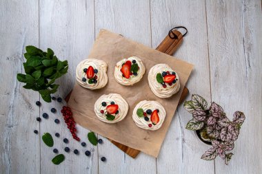 Orman meyveleri ve çileklerle süslenmiş kremalı tatlı. Kremalı pasta, yumurta beyazı ve pudra şekerinden yapılan köpüklü bir kurabiye türüdür. Fransızca 