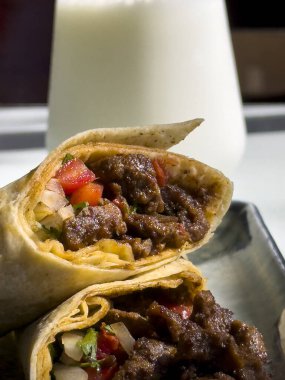 Geleneksel Türk Mutfağı, Tantuni Kebabı, Ünlü Mersin Tantuni. Tantuni tabağı bir restoranda gün ışığında çekildi. Rulo, maydanoz, limon ve ayran soslu et paketi..