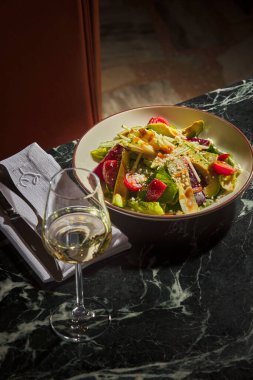 Masada bir kadeh şarap ve bir şişe şarap.