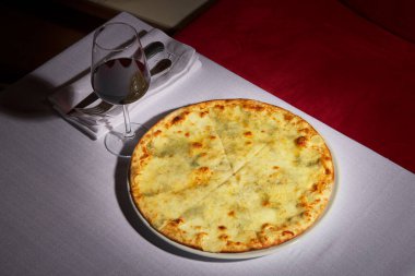 3 peynirli pizza ve bir bardak kırmızı şarap. Margarita pizza lüks bir restoran konsepti..