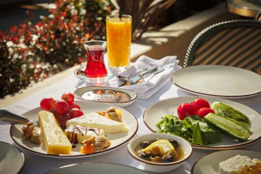 Meşhur Türk kahvaltı masası, zengin ve çeşitli. Geleneksel bir kahvaltı masası, Türk mutfağına özgü, Brek, simit, çay, portakal suyu, bal ve pıhtılaşmış krema gibi yiyeceklerle dolu..