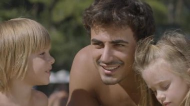 Genç bir aile, anne, baba ve iki çocuk sahilde eğleniyor. Bir kız ve bir oğlanla mutlu bir aile. Çocuklar babayı öper