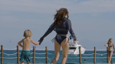 Genç bir aile sahilde koşuyor ve eğleniyor. Bir kız ve bir oğlanla mutlu bir aile yaz tatilinde harika vakit geçiriyor. Tatil ve aile kavramı