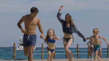 Genç bir aile sahilde koşuyor ve eğleniyor. Bir kız ve bir oğlanla mutlu bir aile yaz tatilinde harika vakit geçiriyor. Tatil ve aile kavramı
