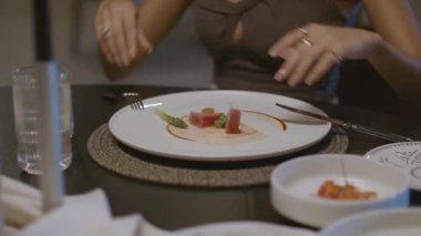 Özel olarak hazırlanmış et yemeği, masada servis edilir ve ilk lokma için kesilir. Seksi ve güzel bir kadın masada sohbet ediyor ve yemek yiyor. Yüksek kalite yakın çekim ve hareket eden kamera.