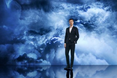 İnce mor cep mendili olan koyu renk takım elbiseli, kendine güvenen bir adam, dramatik bulutlu bir gökyüzü arkaplanına karşı dik duruyor, zarafeti sembolize ediyor, modern erkek modasını, yaşam tarzını ve portresini.