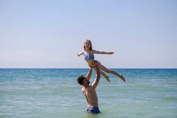 stock image Young father hold up daughter child gymnast girl under sea water, happy family vacation leisure and activity