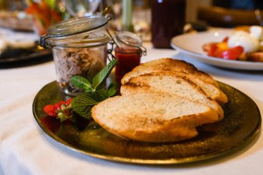 Pate ve kızarmış ekmeklerle servis edilen masa. Kapalı tabakta. Restoran ziyafetinde nefis bir aperatif.