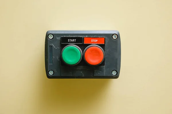 Device with start button and stop button on the wall. Close-up.