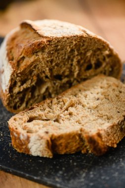 Close-up of dark rye bread cut on a wooden board. Selective focus.