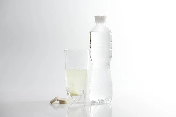 The effervescent tablet dissolves in a glass of water. Glass with soluble medicine on a white background.