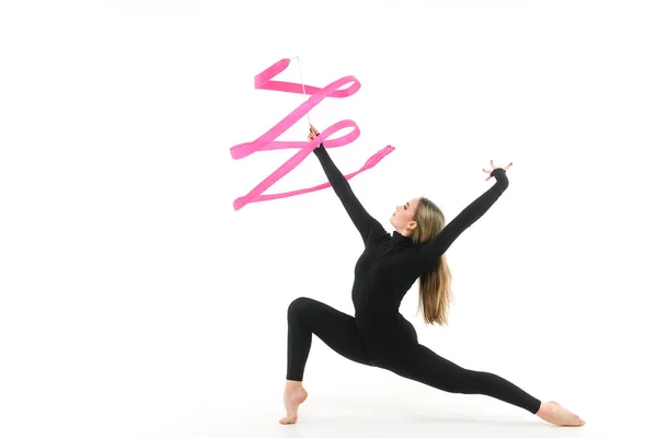 stock image Girl gymnast in a black tight-fitting jumpsuit with a pink ribbon on a white background