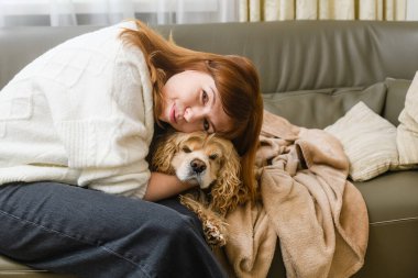 Şirin, genç, beyaz kadın ev sahibi Amerikan cocker spaniel 'i okşar ve yüzünü ona bastırır. Aile kavramı