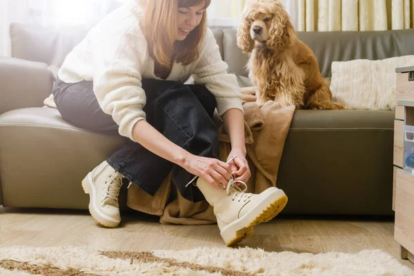 那女孩在遛狗之前系上鞋带 狗在沙发上等着 — 图库照片