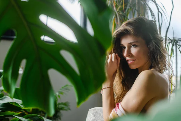 stock image Portrait of cute woman with home house plants, happy female enjoy stay in cosy interior with day light