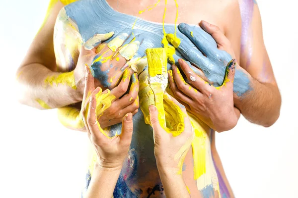 Man covering woman's breast. Body painted with paint. White background. Body art.