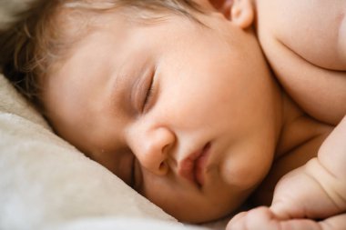 Tatlı bebek beşik yatağında uyur. Minik yumrukları, küçük kulakları, yumuşak cildi, ilk saçları, huzur içinde dinlenen bir bebeği vardır.