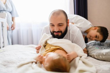 Anne, baba ve ağabeyin ailesi dikkatsiz yeni doğan bebek, yeni doğan bebek, beşikteki aile çocuğu.