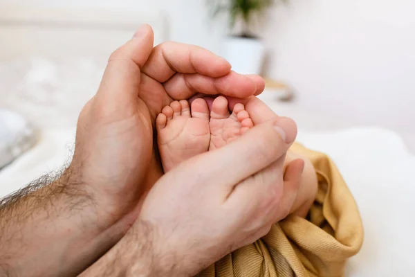 小さな赤ちゃんのつま先で父親の手 家族の愛と団結 父親は幼児の新生児の足 皮膚を皮膚に保持します — ストック写真