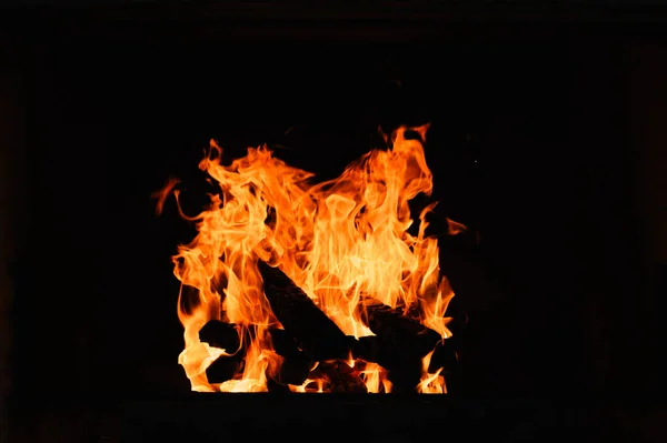 レンガの暖炉で火を燃やして 閉じる 火の木 カラフルな炎とボケのライトで暖炉で 黒いぼやけた背景に大きな炎 — ストック写真