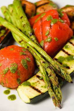 Beyaz tabakta pesto soslu ızgara sebze. Yakın plan..