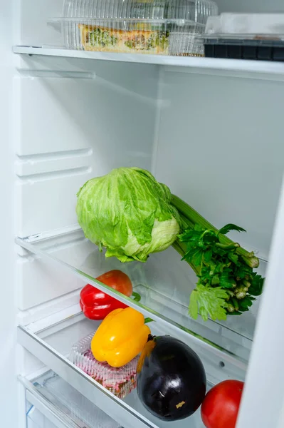 Fresh Vegetables lying on the shelf in the fridge. Fresh vegetable storage concept.