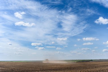 Traktör geniş tarlalarda sürerek tohumları saflaştırmak için özel yataklar yapıyor. Tarımsal araç kırsalda çalışıyor.