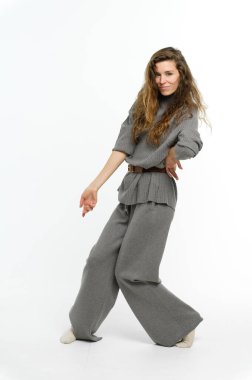 Beyaz arka planda dans eden çekici genç bir kadın. Tam yükseklik.