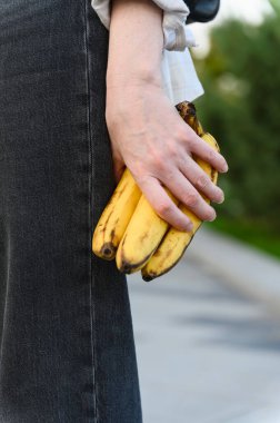 Olgun muzları tutan bir kadının yakın çekimi. Hızlı atıştırma konsepti.