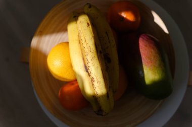 İçerideki ahşap bir tabakta tropikal meyveler. Yakın plan. Yukarıdan görüntüle.