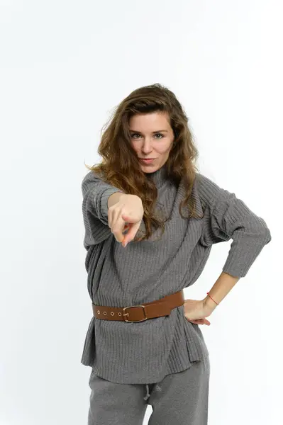 stock image The woman points her finger straight ahead. Looking into the camera. White background.