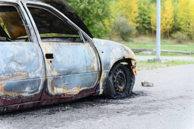 Yanmış araba enkazı doğada yol kenarında terk edilmiş..