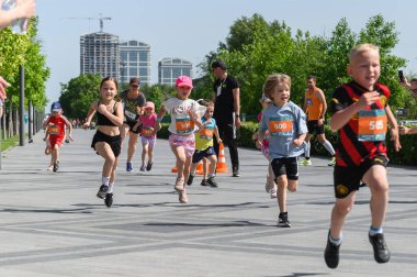 Dnipro, Ukrayna, 25 Mayıs 2025. Bir grup genç çocuk, halka açık bir spor etkinliği sırasında bir koşu yarışmasına katılıyor..
