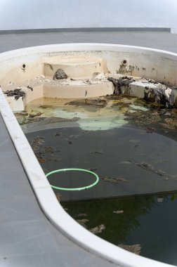 Kirli terk edilmiş yüzme havuzunda durgun su ve enkaz var. Gün ışığı, görünen kimse yok..