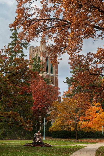East Lansing MI - October 18, 2022: Beaumont tower during the Fall as a worker mows the lawn. High quality photo