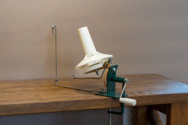 Masa üstüne bağlanmış örgü örmede kullanılan mekanik iplik ya da makara. - Evet. Yüksek kalite fotoğraf