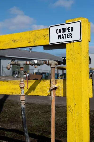 Stock image Source of safe water that is safe for human consumption located by a yellow fence with faucet signage stating camp water. High quality photo