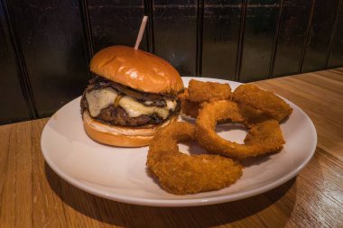 Eritilmiş peynirli leziz burger ve fotokopi uzayı ile kızarmış soğan halkaları. Yüksek kalite fotoğraf