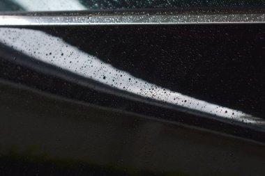 Araba boyasının zeminine yağmur damlaları yağıyor.