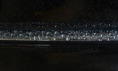 Araba boyasının zeminine yağmur damlaları yağıyor.