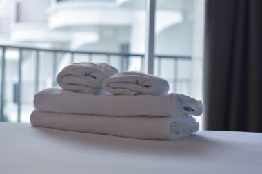 Yatak odasında, yatağın üzerinde havlular var..