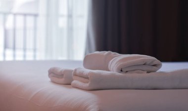 Yatak odasında, yatağın üzerinde havlular var..