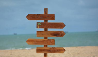 Arka planda bir plaj ve yol işareti var..