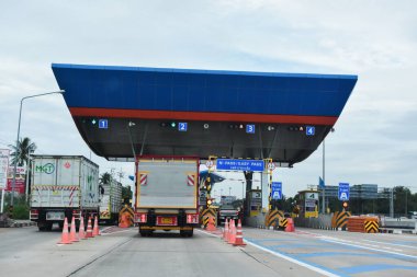 Otobanda çalışan birçok araba var. Geçiş gişesi ve ekspres yol kartları var. Fotoğraf 2 Ağustos 2024 'te Tayland otoyolunda çekildi..