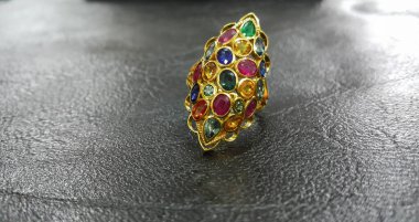 Çok renkli mücevherlerle süslenmiş altın yüzük, özenle seçilmiş mücevherler, pahalı mücevherler.